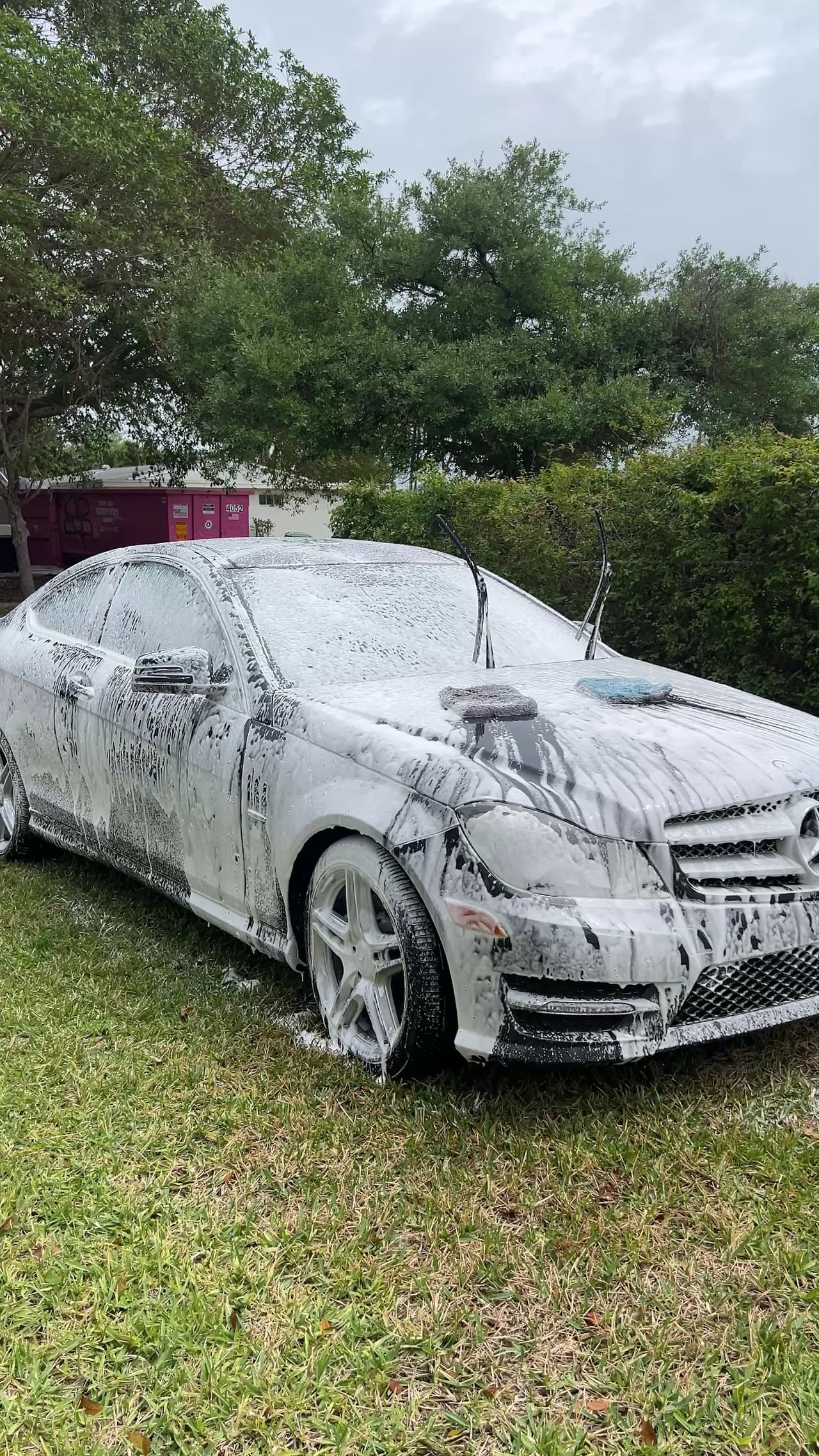 Mercedes sedan covered in snow foam during the wash