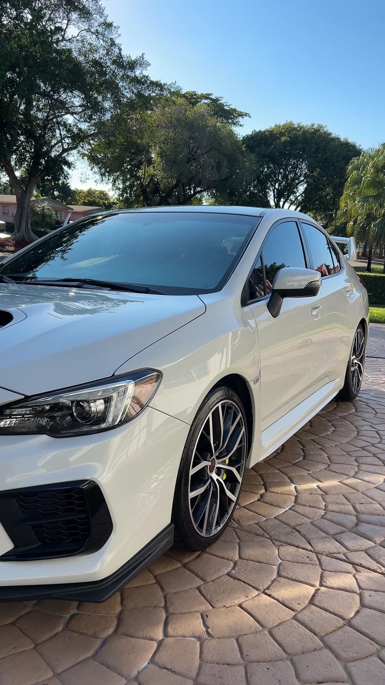 White Subaru WRX detailed on a paver driveway